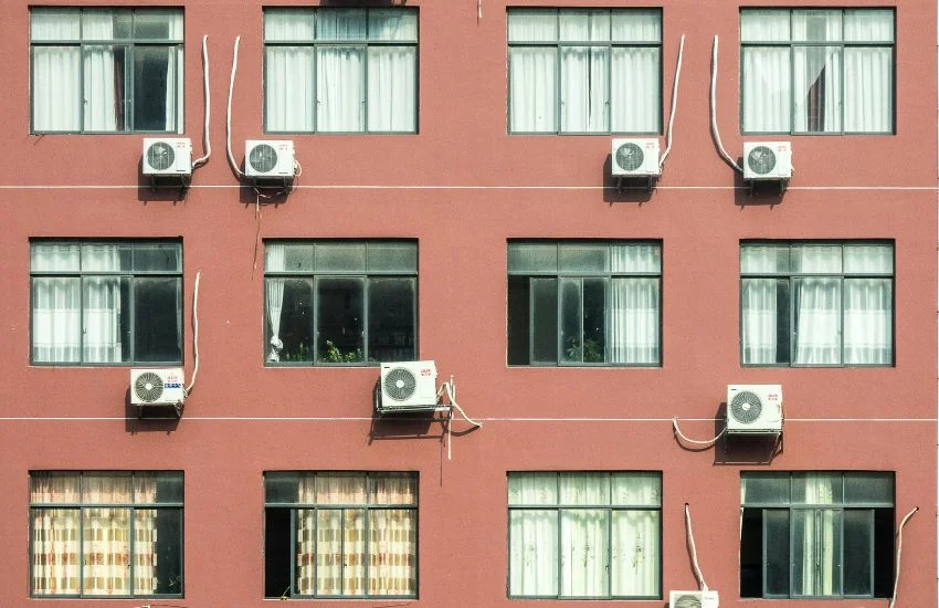 Fachada de edificio con múltiples unidades exteriores con diferentes modos de instaladas bajo las ventanas